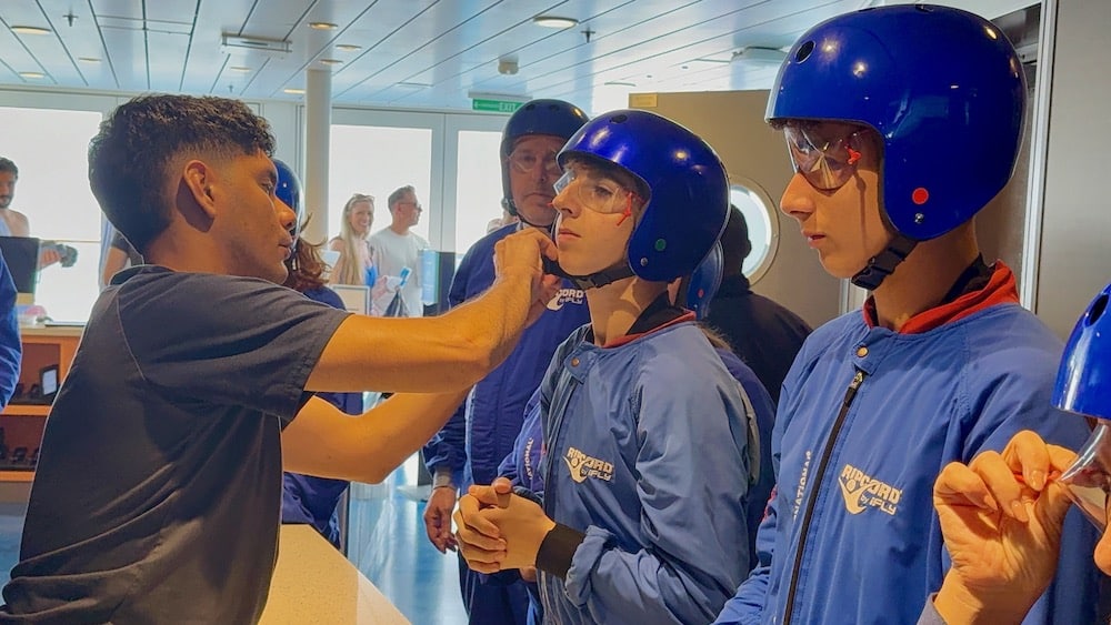 man securing helmet to teen