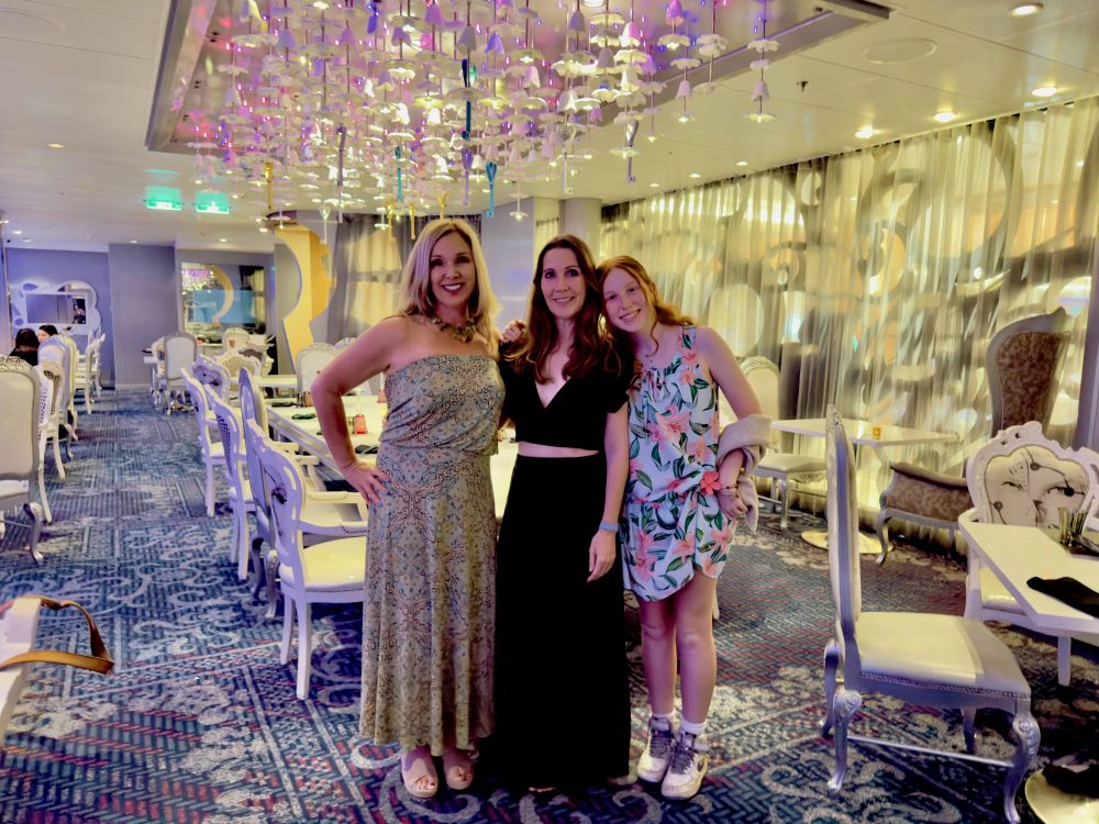 Two moms and a teen girl dressed up in restaurant.