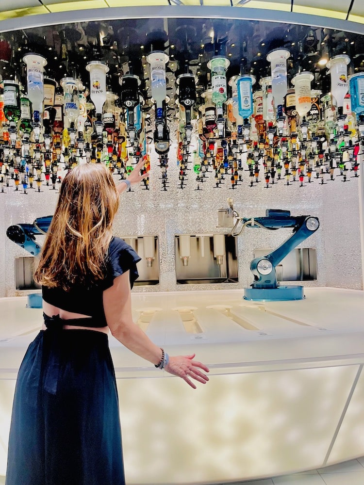 woman watching robot arms make a drink