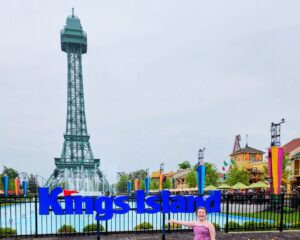 Kings Island an ultimate parent guide. Kings Island Sign with little girl in front of fountain and Eiffel tower.