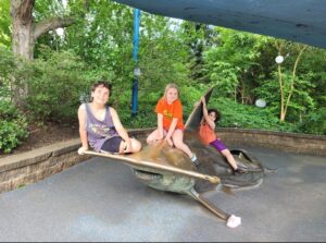 Three kids posing on a hammerhead shark. Things to do with kids in Columbus, Ohio.