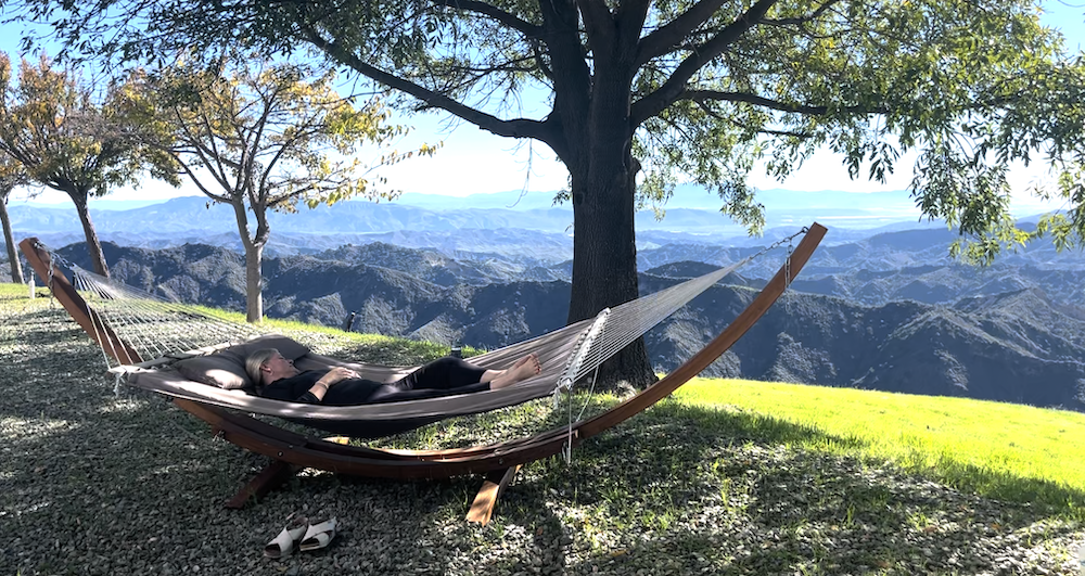 woman snoozing on hammock on mountain ridge