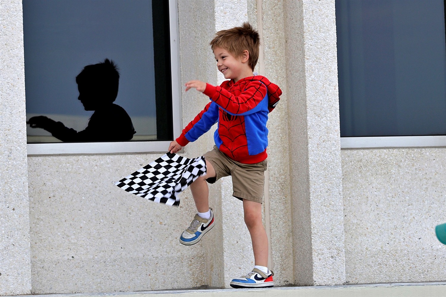 Child waving a checkered flag in the stands at the Indy 500