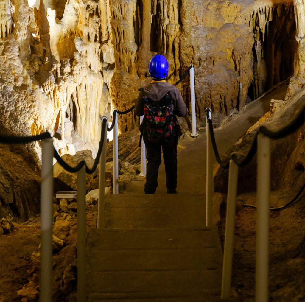 A person walking on a path inside a cave. 