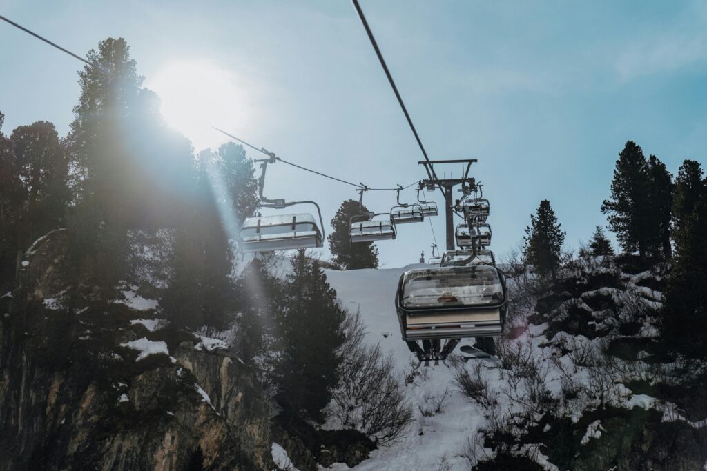 Chairlift going up and over a snowy mountain.