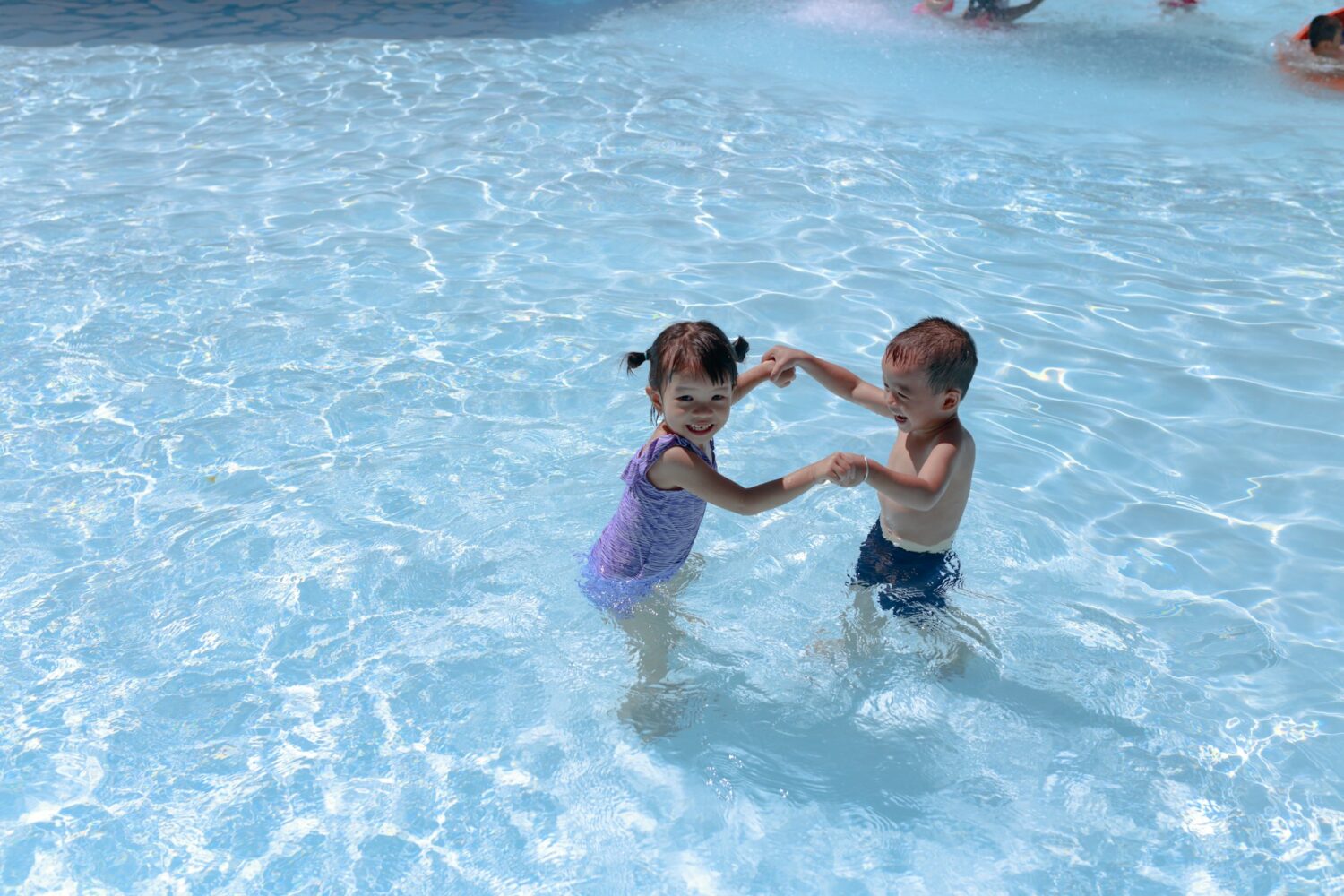 Two kids playing in a shallow pool. Oceanfront resorts in myrtle beach for families. 