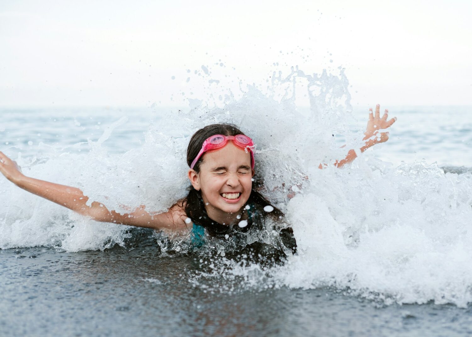 Girl splashing in the waves in the ocean. Best oceanfront family resorts in Myrtle Beach.