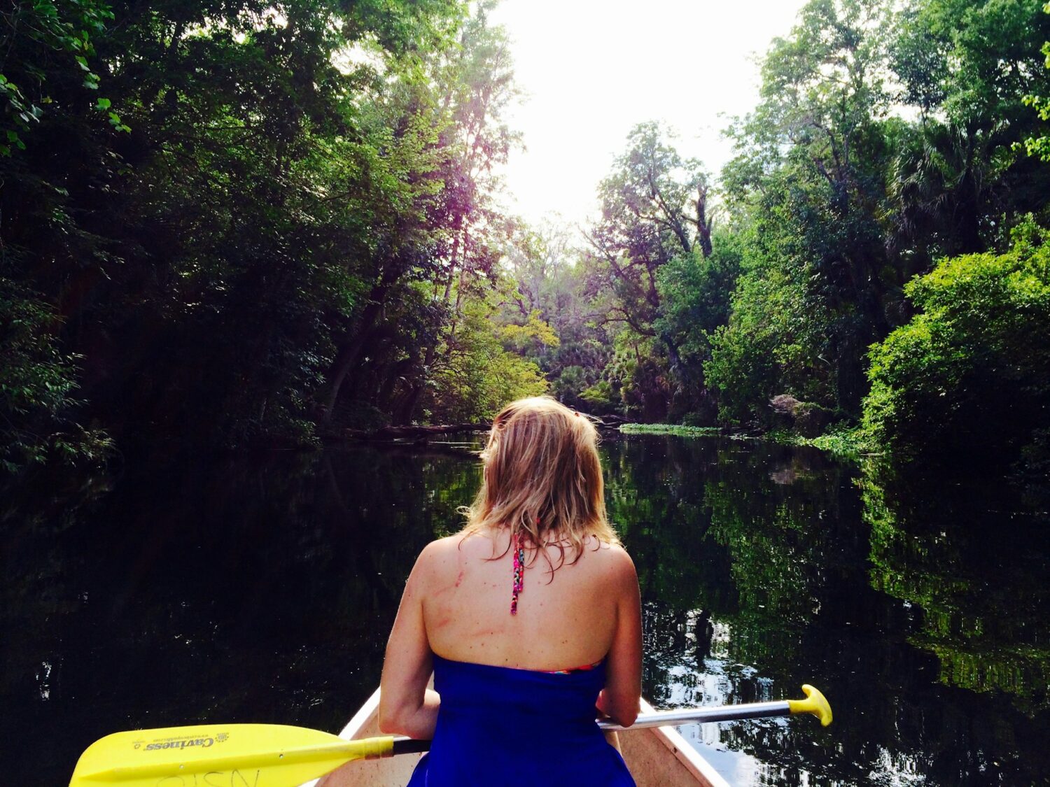 Woman kayaking through Wekiwa Springs. Hot springs in Florida. Best natural springs. 