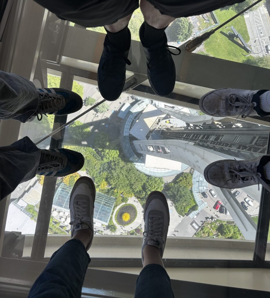a family standing on a glass floor with their feet in frame