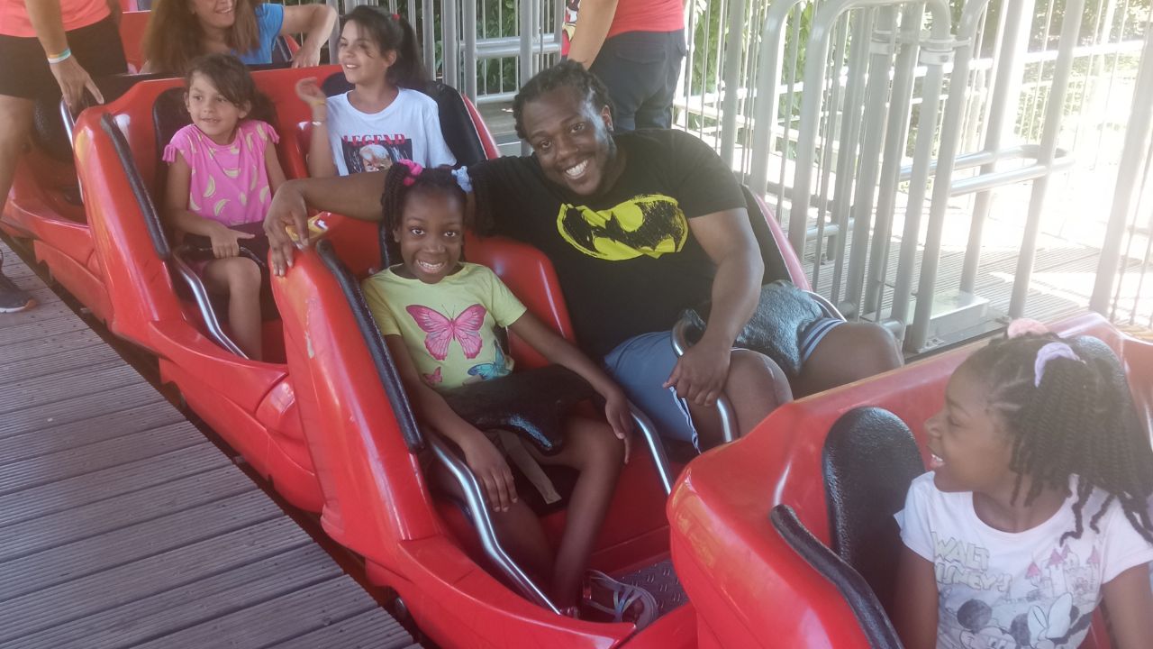 Father and daughter riding a rollercoaster together as an activity to do in Rome with kids