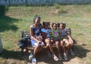 Mom and daughters sitting on a park bench near MagicLand amusement park in Rome