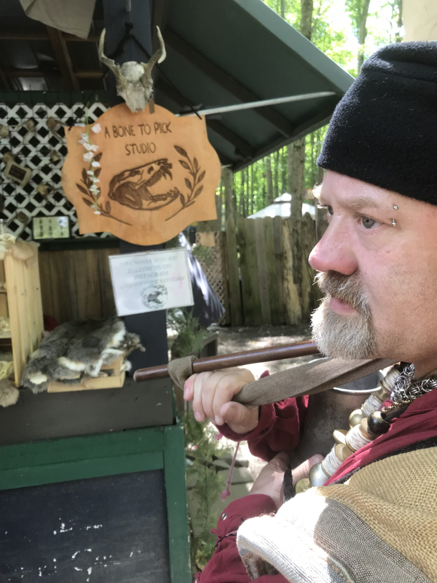 Man standing in front of shopping area at Great Lakes Medieval Faire. 