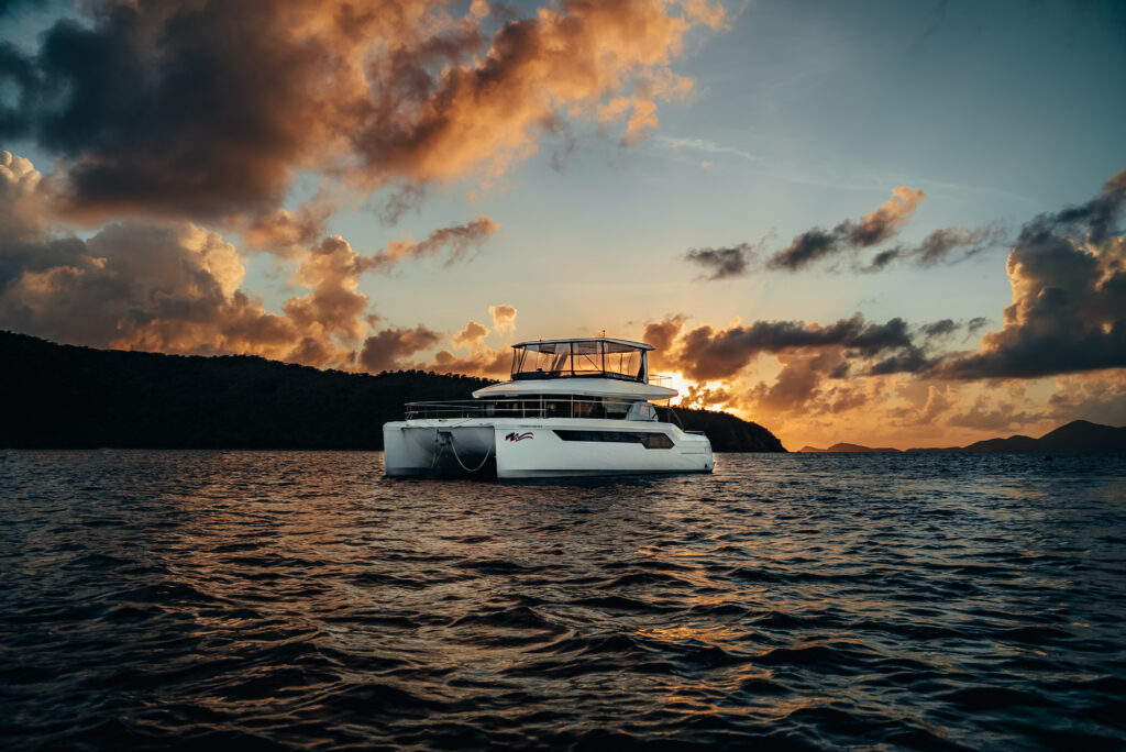 yacht in ocean during cloudy sunset hour