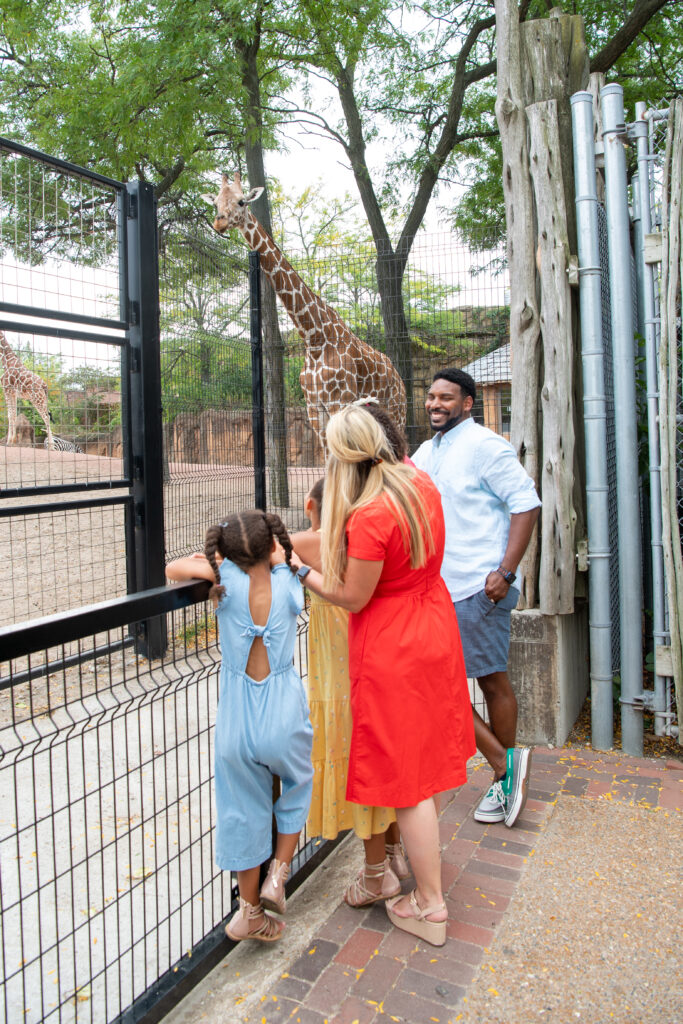 family standing next to giraffe enclosure - chicago with kids