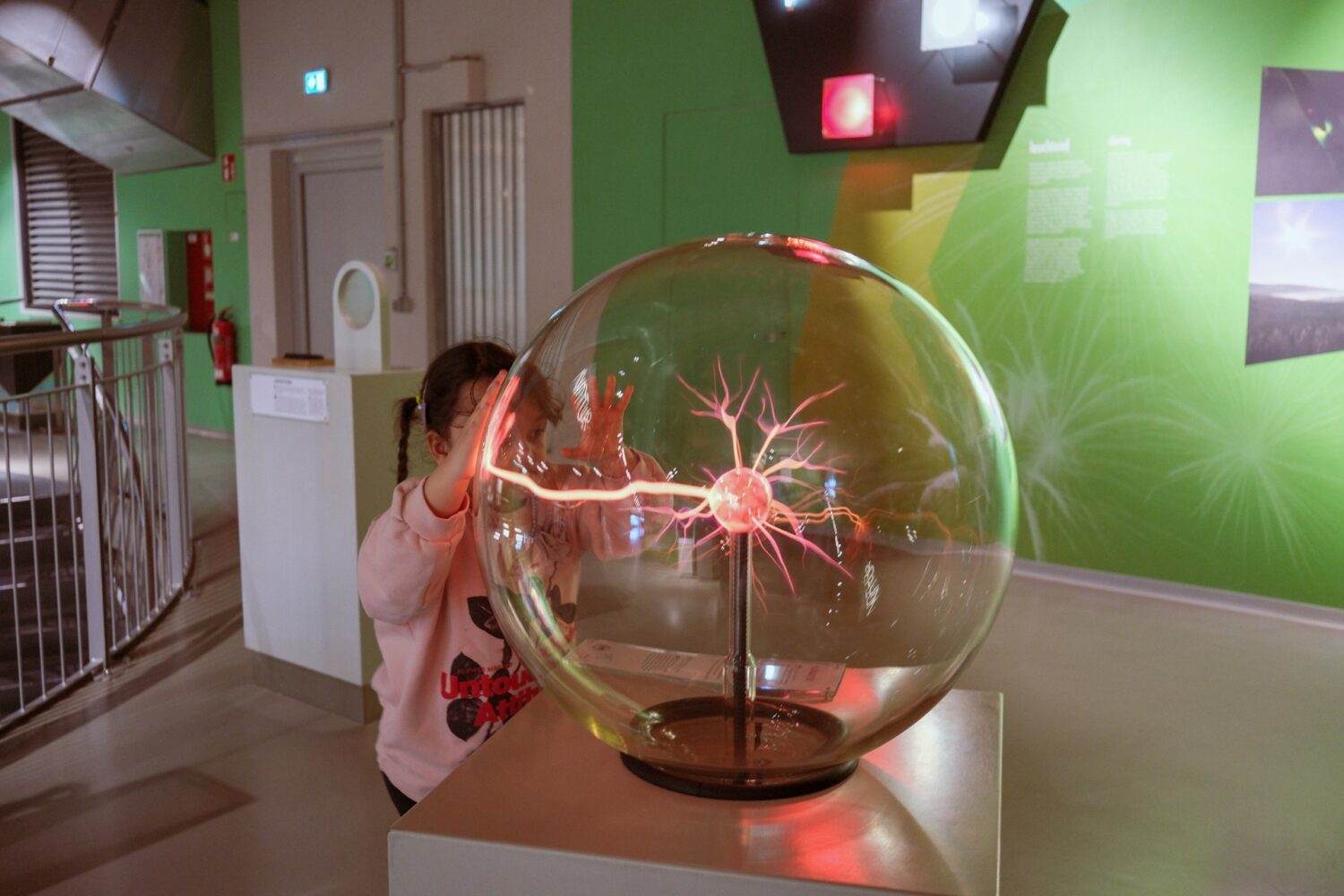 Kid touching a plasma ball at a science museum. Kansas City with kids.