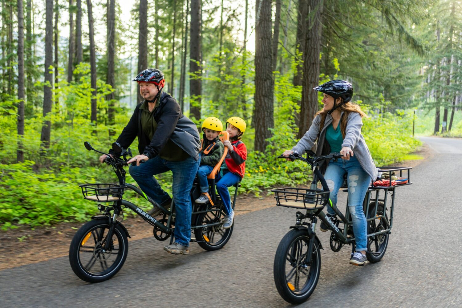 Family riding bikes on paved trail through woods. Cuyahoga Valley National Park for families.