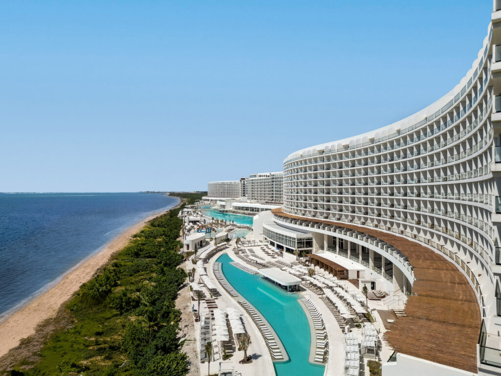 aerial side view of hotel, pool, and ocean