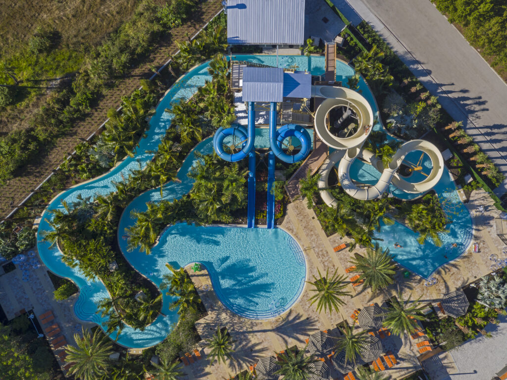 aerial view of lazy river and water slides among palm trees